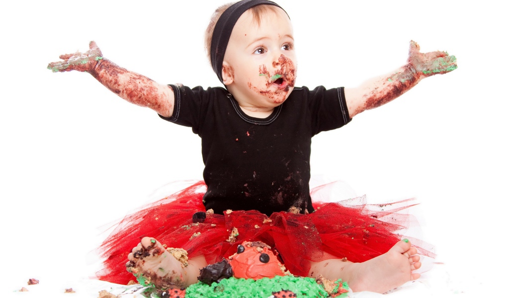 Маленькая смешная девочка в торте на белом фоне