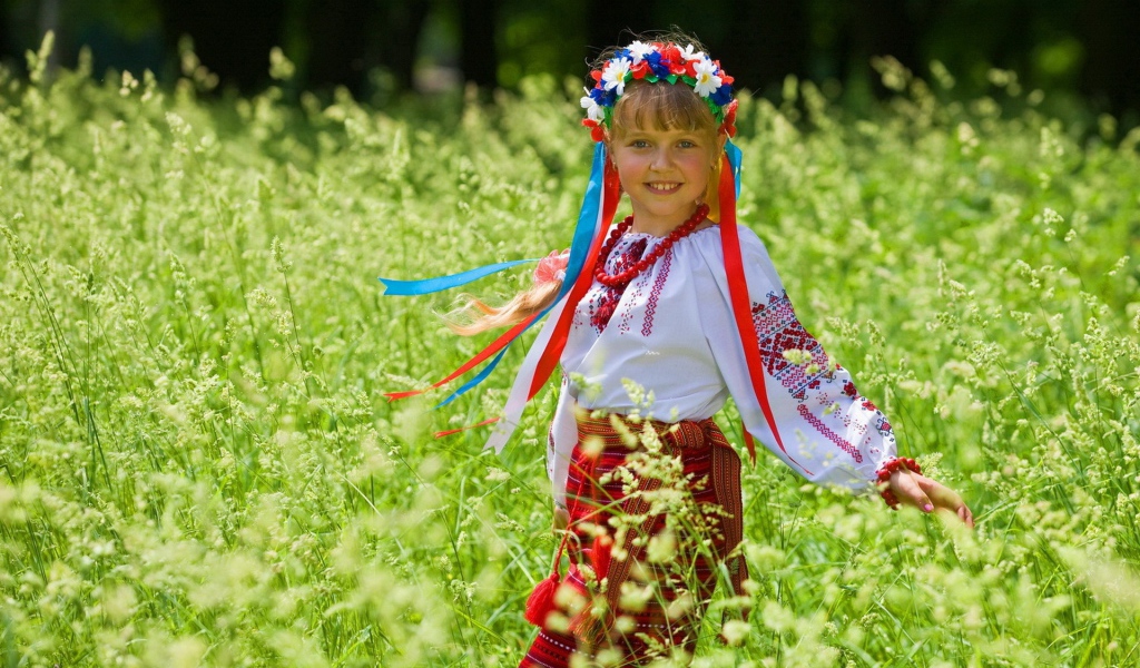 Маленькая девочка в костюме с венком на голове