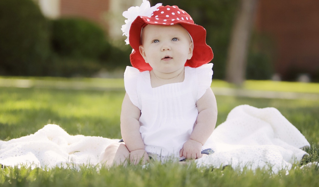 Маленькая девочка в белом платье и красной шляпе