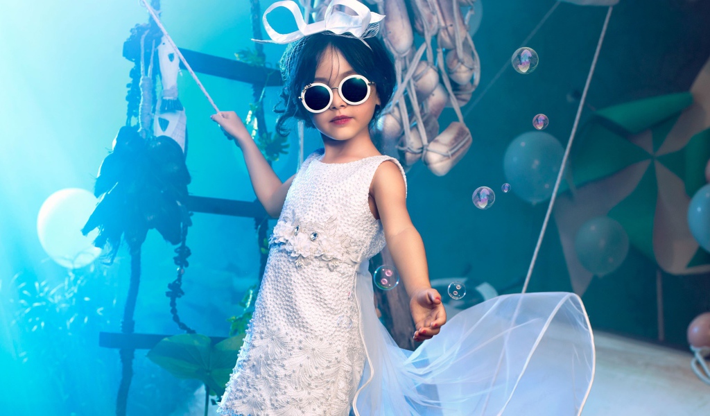 Маленькая девочка в белом платье и черных очках