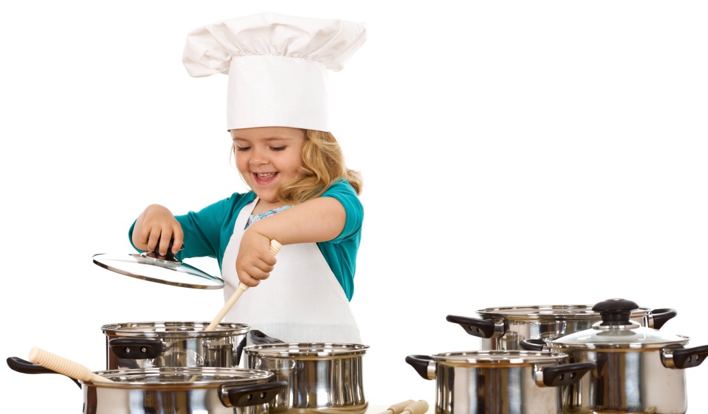 Маленькая девочка в костюме повара на кухне