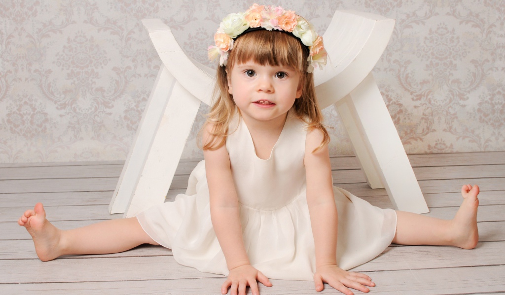 Маленькая девочка сидит на шпагате