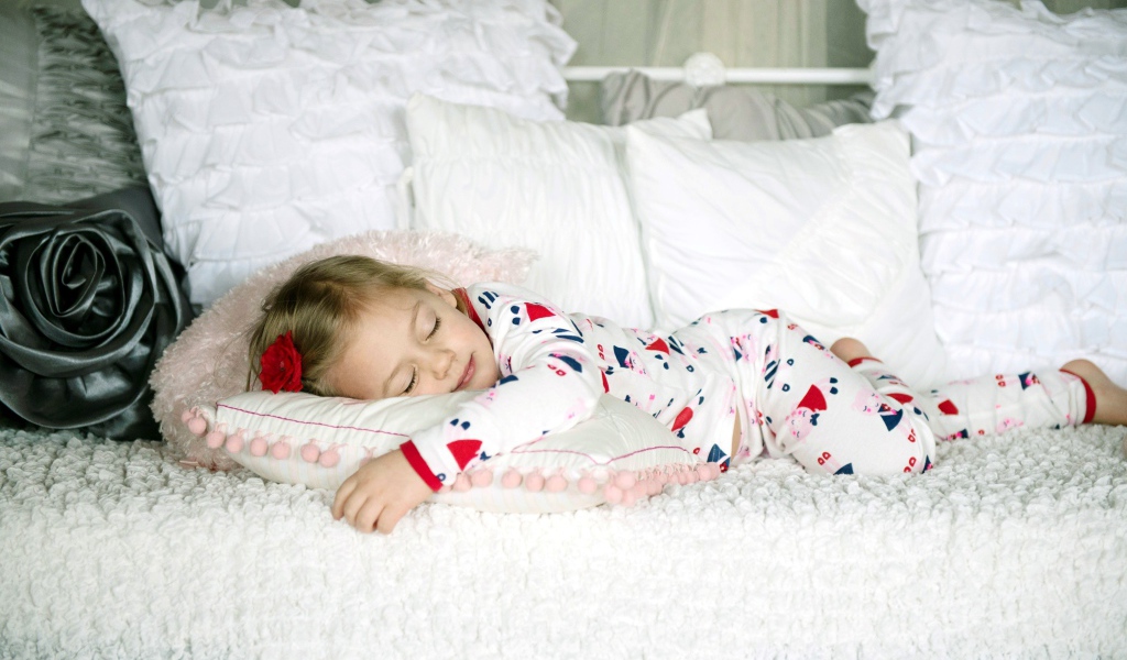 Маленькая девочка спит на подушке