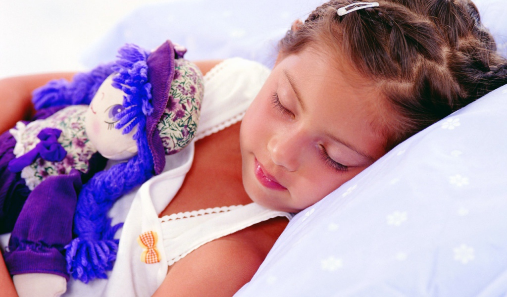 Маленькая девочка спит с игрушкой