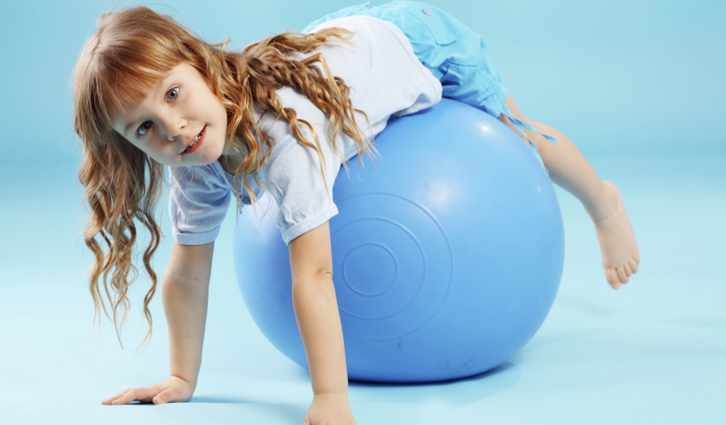Маленькая девочка с большим голубым мячом
