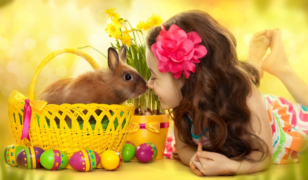 Маленькая девочка с кроликом в корзине на праздник Пасха