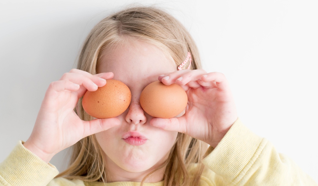 Маленькая девочка с яйцами в руках