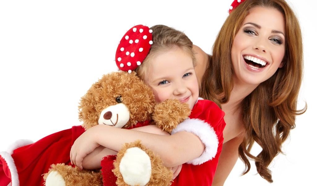 Маленькая девочка с мамой обнимает игрушечного медвежонка