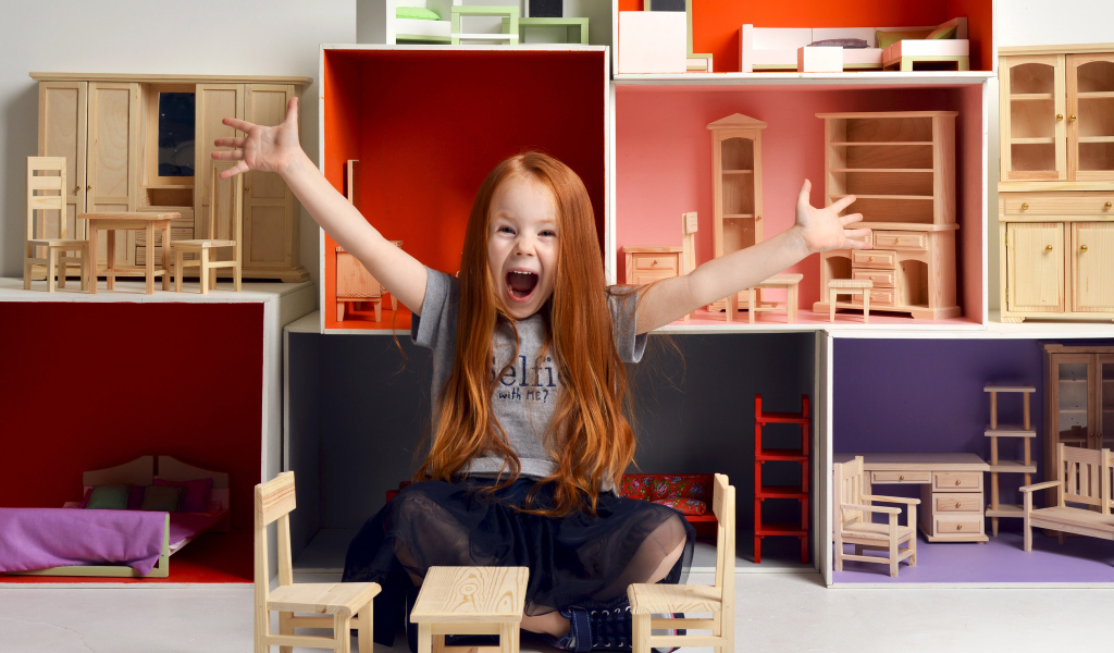 Маленькая девочка с игрушечной мебелью