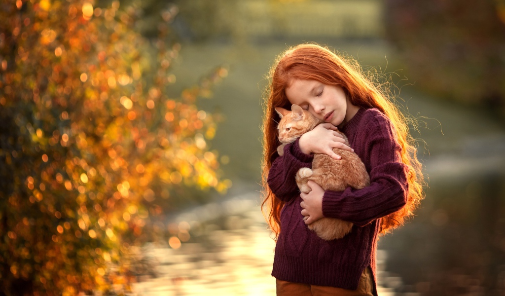 Маленькая рыжеволосая девочка с котенком на руках