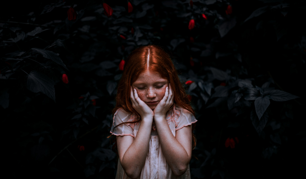 Маленькая рыжеволосая девочка с закрытыми глазами 