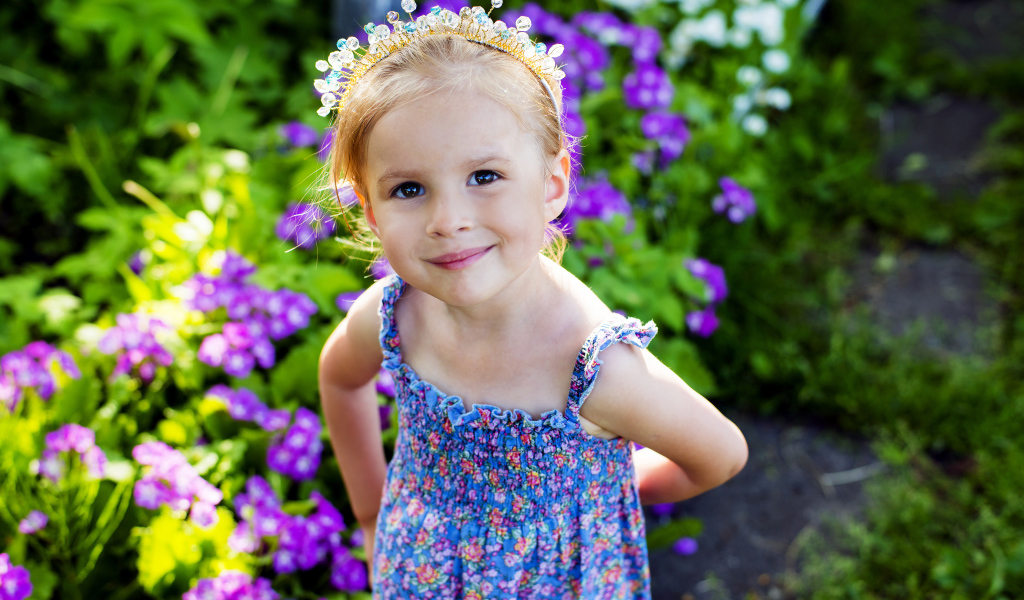 Маленькая улыбающаяся девочка с украшением в волосах 