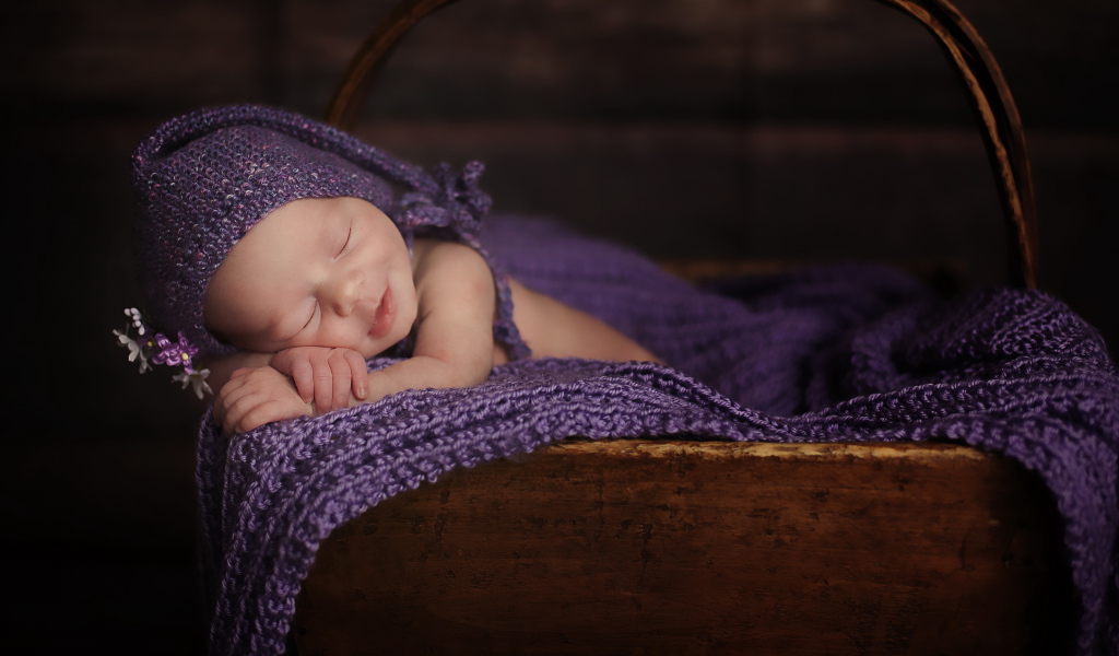 Новорожденный ребенок улыбается во сне