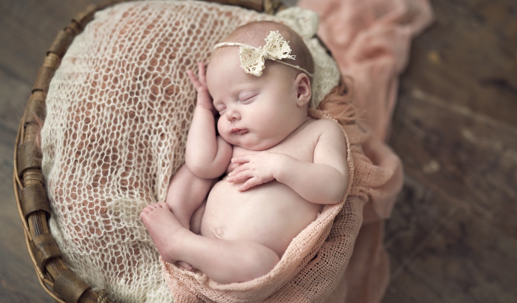 Новорожденная спящая девочка в корзине 
