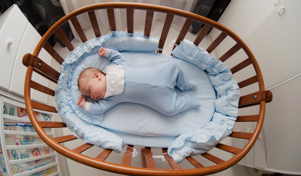 Спящий грудной ребенок в кроватке