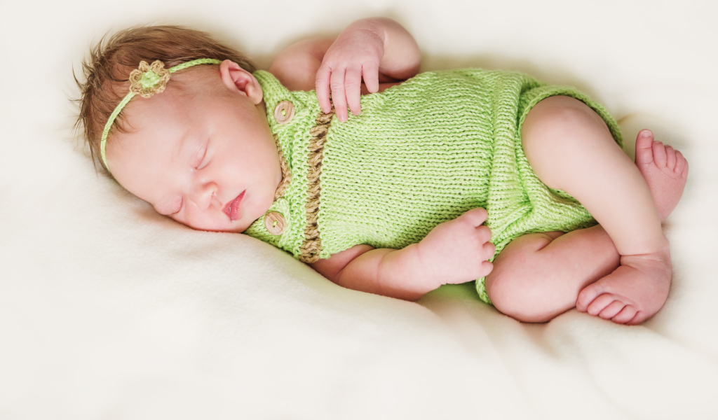 Спящий младенец в вязаной одежде