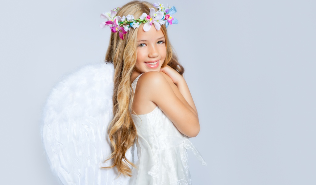 Улыбающаяся милая девочка в костюме ангела