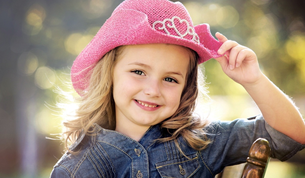Улыбающаяся девочка в розовой шляпе