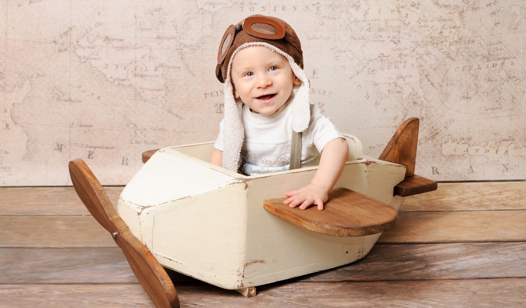 Улыбающийся маленький мальчик в игрушечном самолете