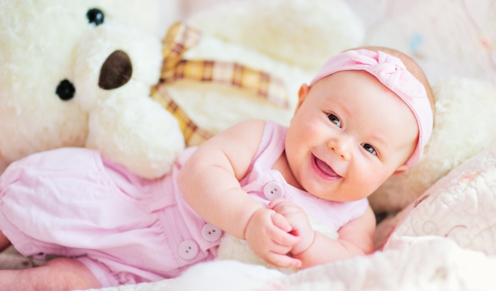 Улыбающаяся маленькая девочка с большим плюшевым медведем