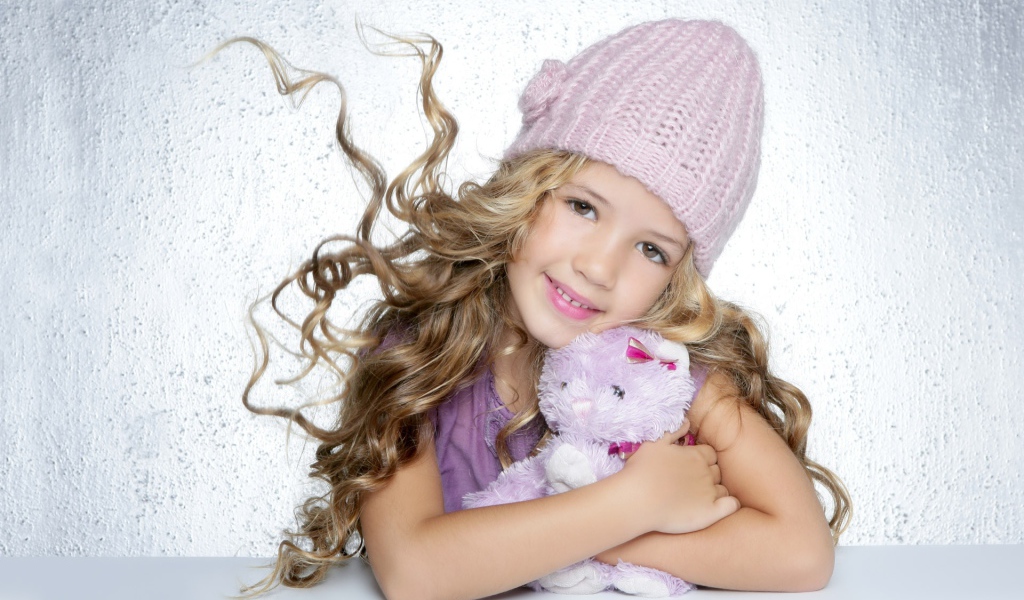 Милая светловолосая девочка с игрушкой