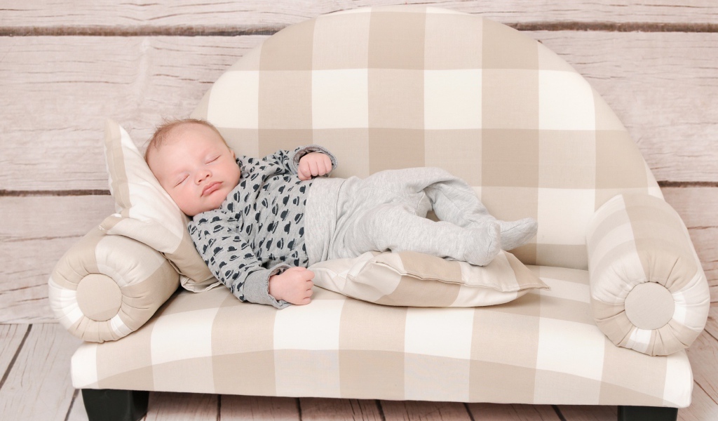 Грудной ребенок спит на диване