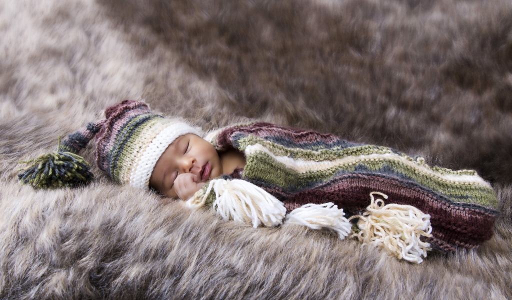 Младенец спит на меховом покрывале