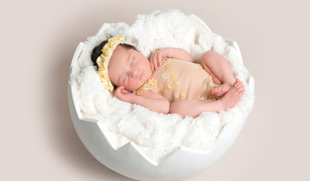 Младенец спит с мягкой белой скорлупе