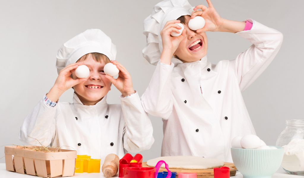 Два маленьких мальчиках в костюмах повара на кухне