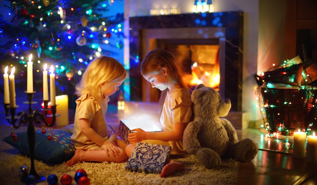 Две маленькие девочки с игрушками у камина