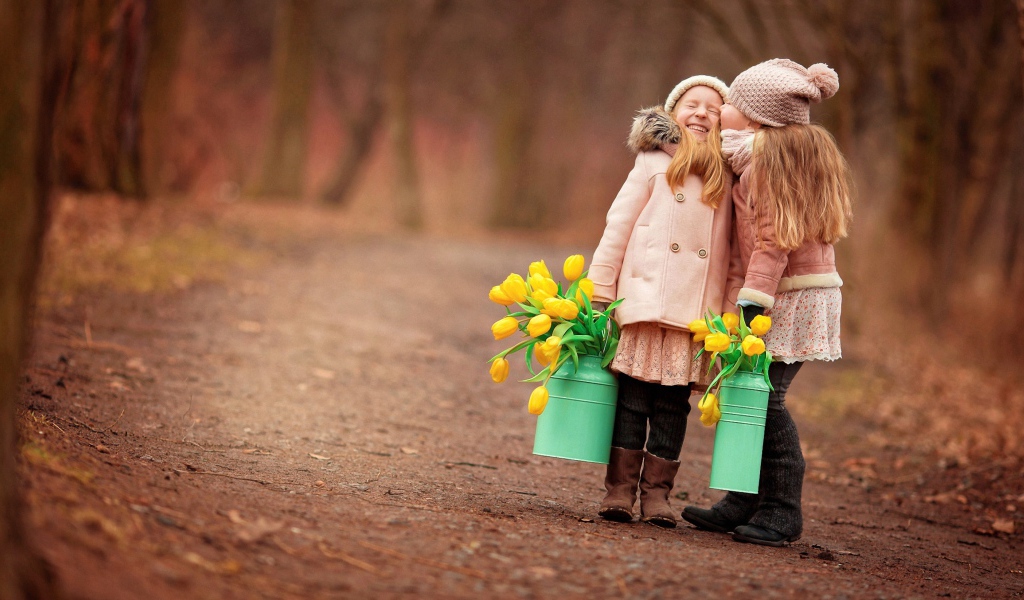 Две маленькие девочки с желтыми тюльпанами весной