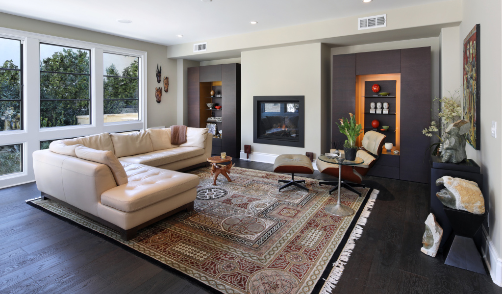 Стильная гостинная комната с белым кожаным диваном и ковром на полу