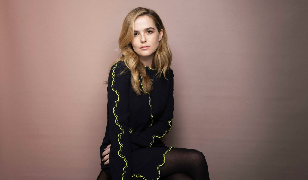 Актриса Зои Дойч в красивом платье сидит на стуле 