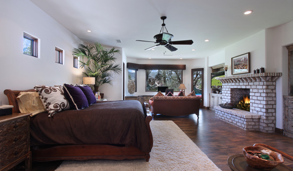 Спальная комната с большой кроватью с камином