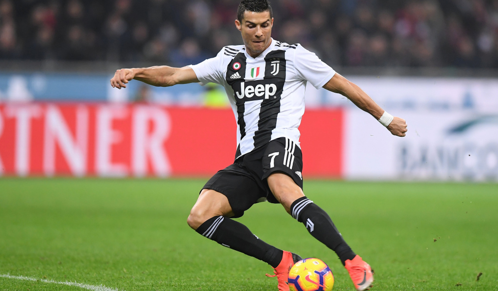 Футболист Криштиану Роналду отбирает мяч на футбольном поле 