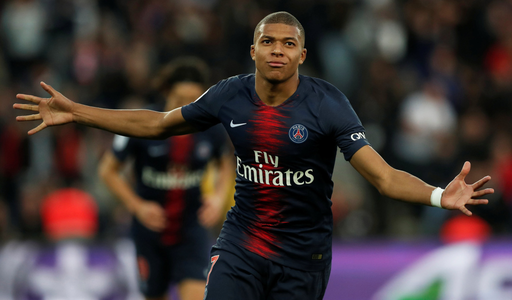 Французский футболист Килиан Мбаппе бежит по полю