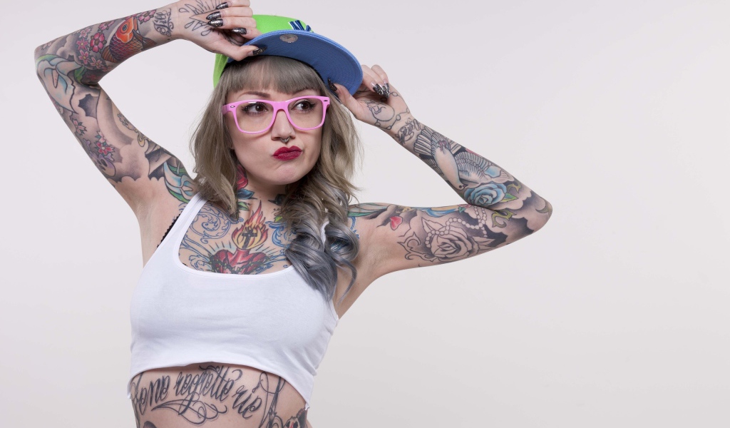 Девушка в кепке с татуировками по телу