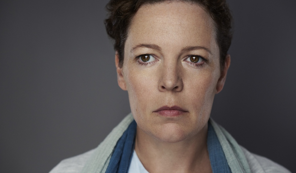 Грустная актриса Оливия Колман на сером фоне