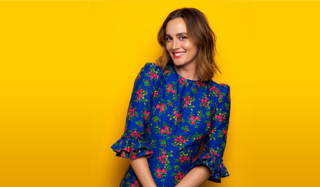 Улыбающаяся актриса Лейтон Мистер в красивом платье на желтом фоне 