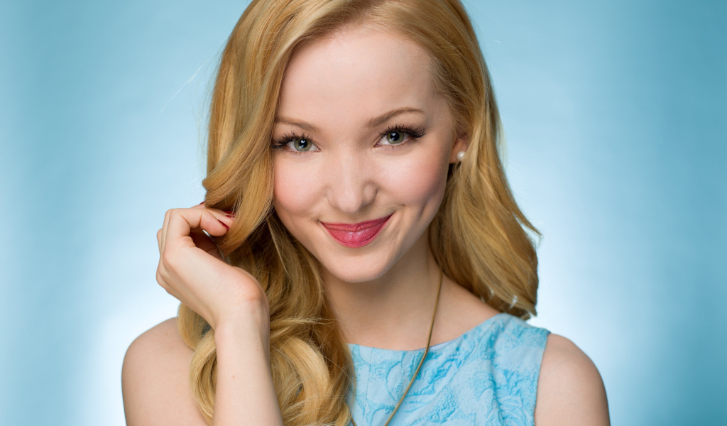 Улыбающаяся красивая девушка актриса Дав Кэмерон на голубом фоне