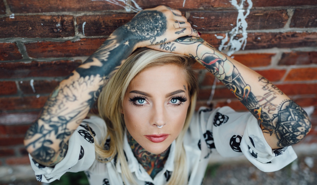 Молодая девушка блондинка с татуировками по телу
