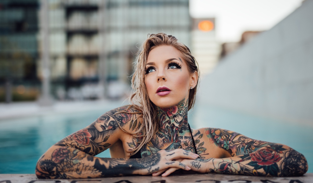 Молодая девушка с красивыми татуировками на теле