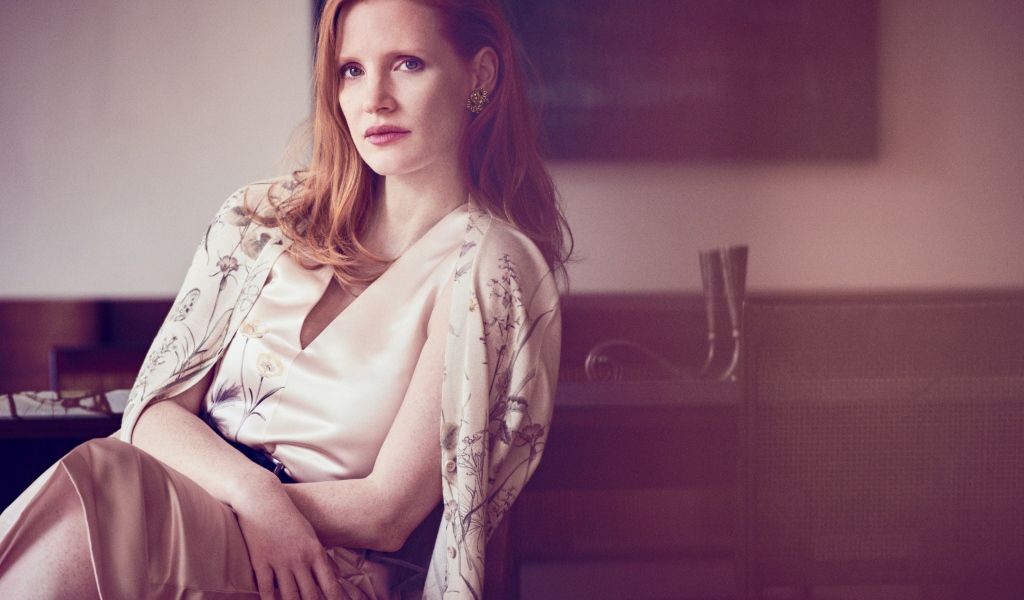 Молодая рыжеволосая актриса Джессика Честейн сидит на стуле