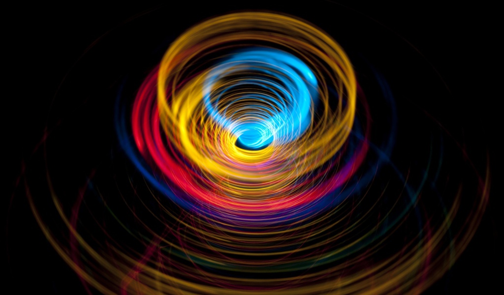 Разноцветные круги в воронке на черном фоне