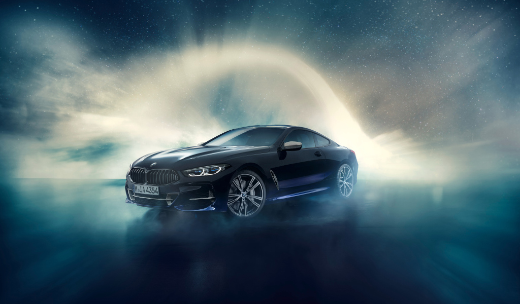 Черный автомобиль BMW M850i, 2019 года на фоне неба