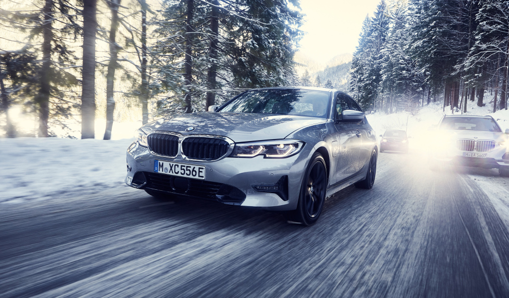 Серый автомобиль BMW 330e 2019 года на скользкой трассе