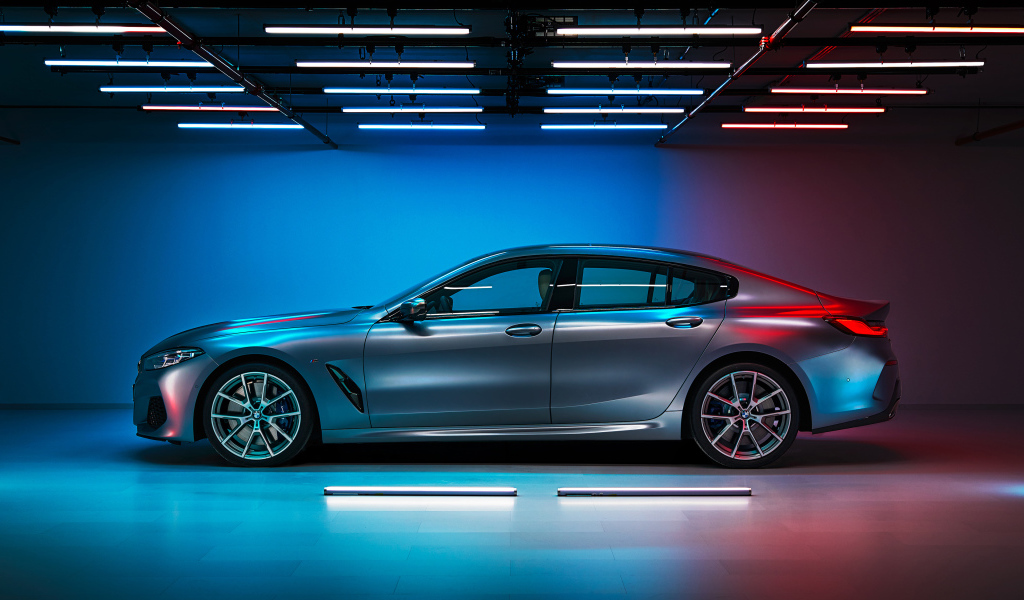 Серебристый автомобиль BMW M850i,  2019 года вид сбоку