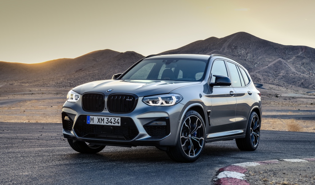 Серебристый автомобиль BMW X3  на асфальте