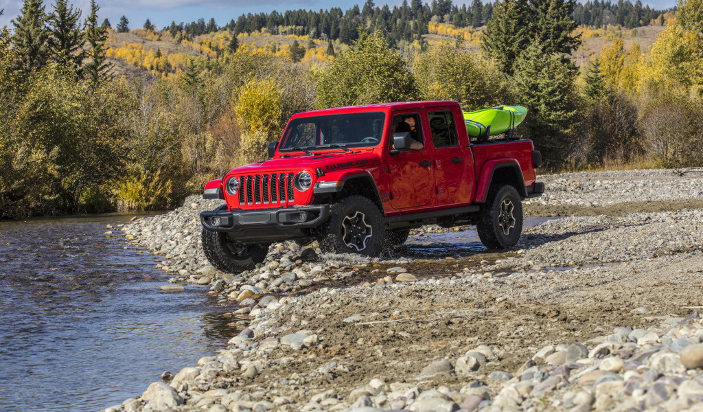 Красный пикап Jeep Gladiator Rubicon, 2020 года у реки