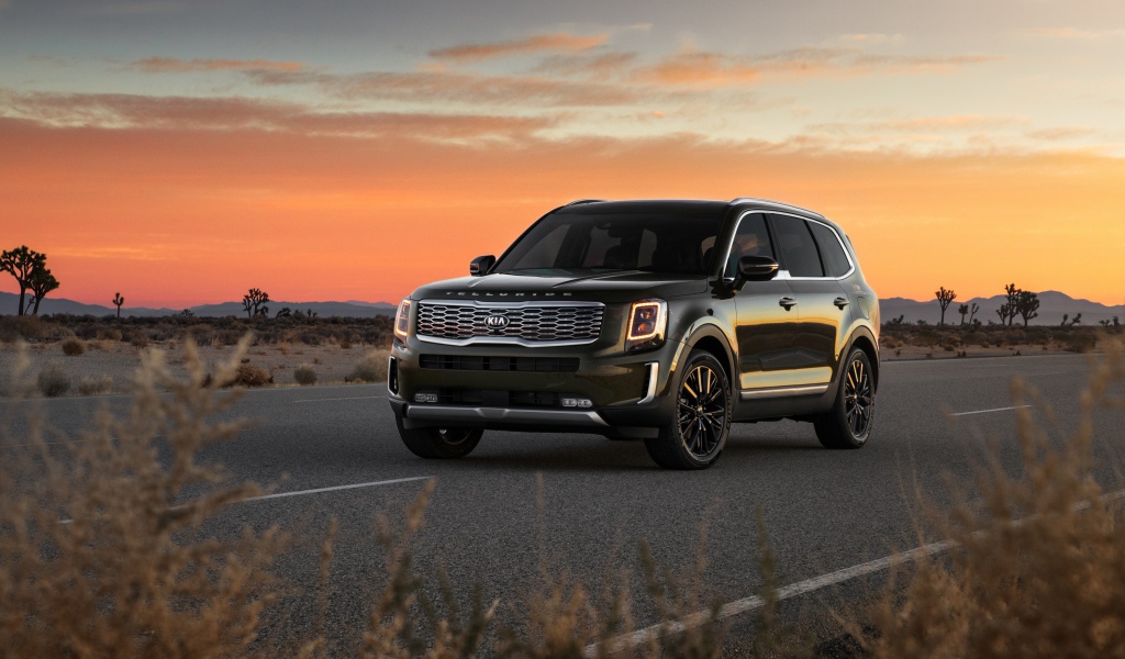 Черный внедорожник Kia Telluride, 2020 года на фоне заката 